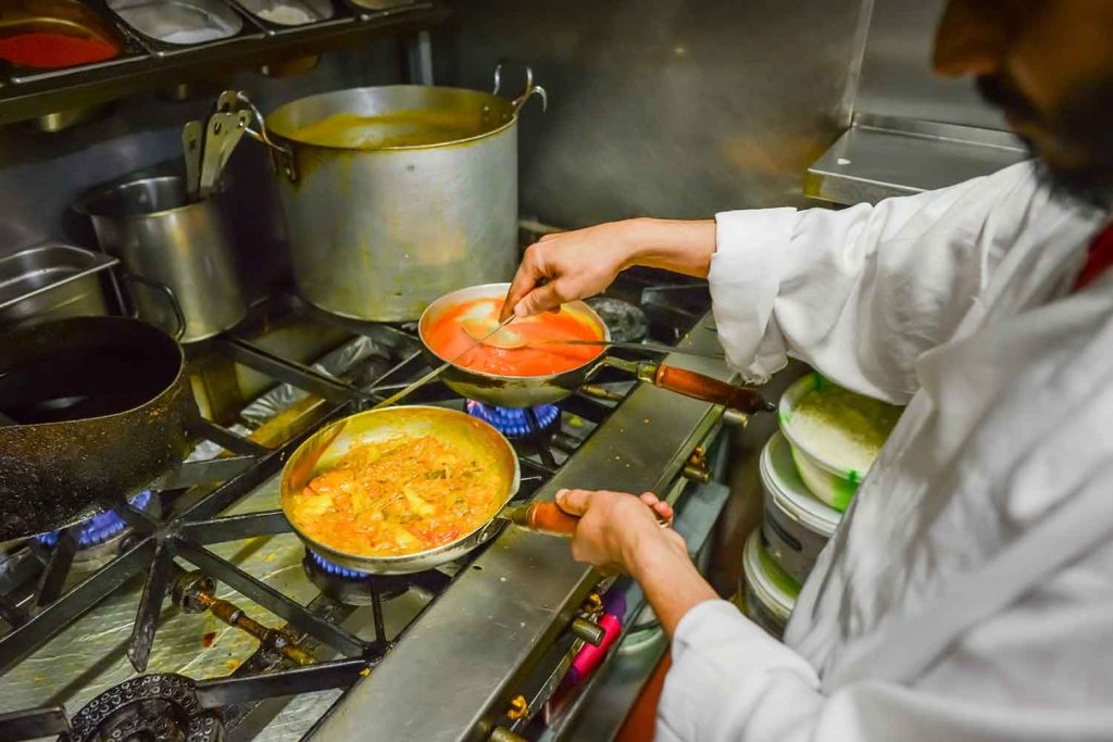 Cooking in different pans for gluten-free requirements, Indian restaurant, Brick Lane.
